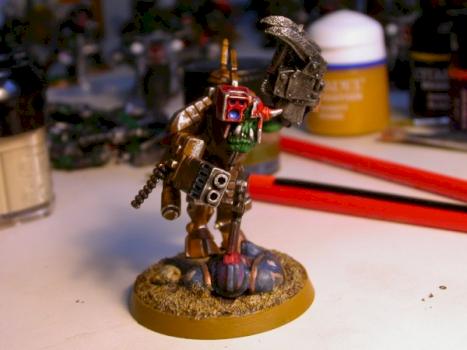 Ork meganob in a stealth suit, standing on a Space Marine corpse. by aca121